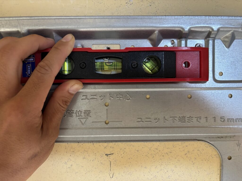 Checking the air conditioner mounting plate with a spirit level