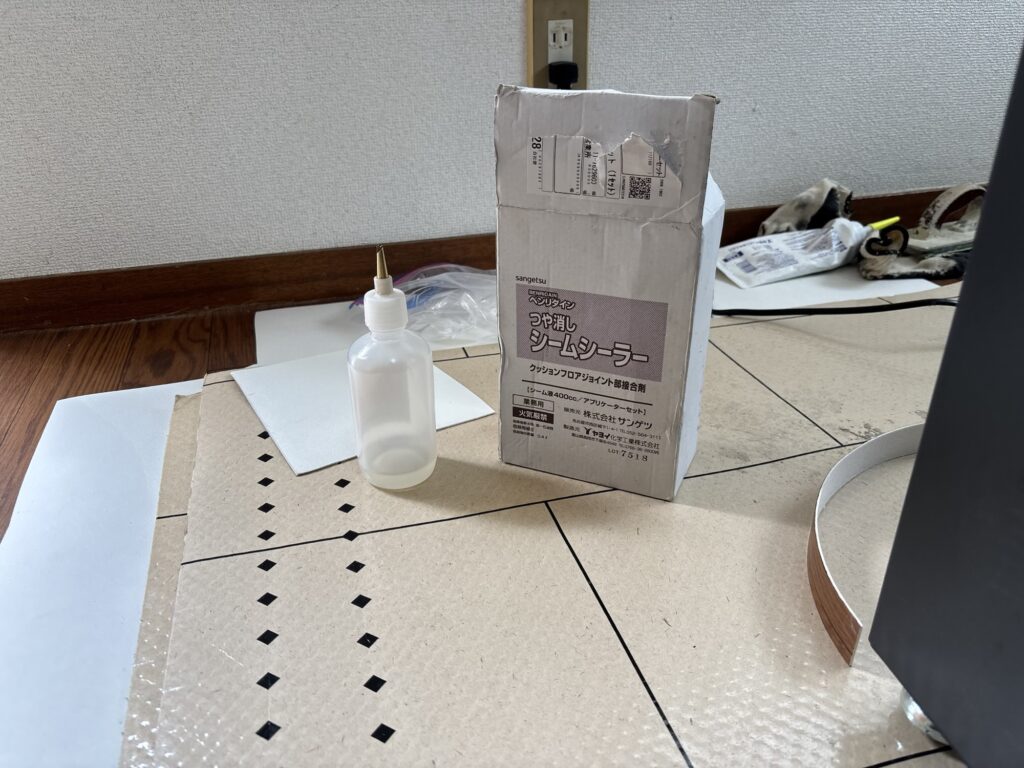 Close-up of seam sealer being applied to the joint of newly installed cushion flooring for a durable and water-resistant finish.