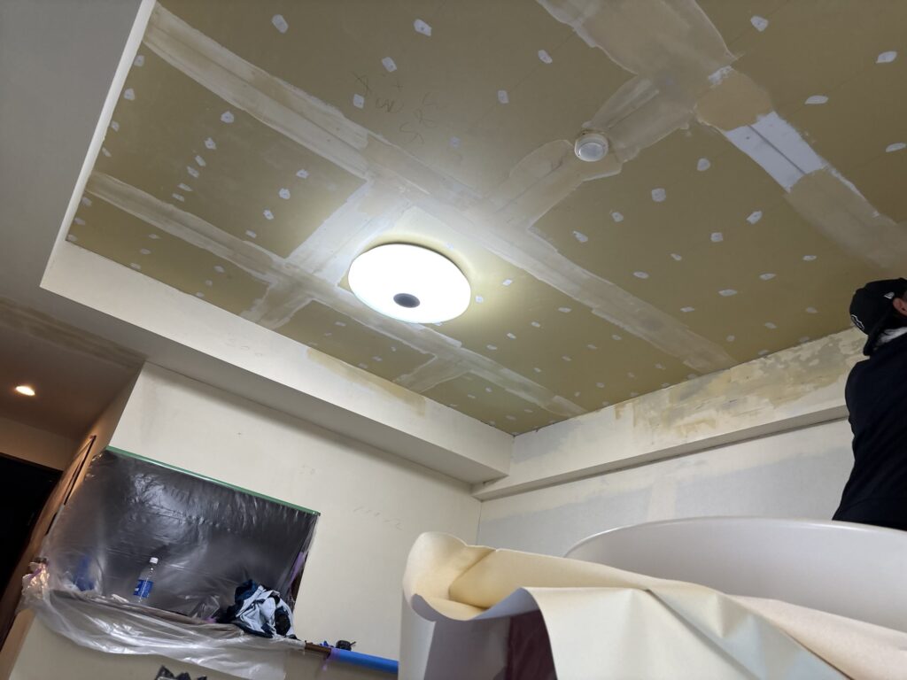 Joint compound drying on repaired ceiling and wall surfaces.