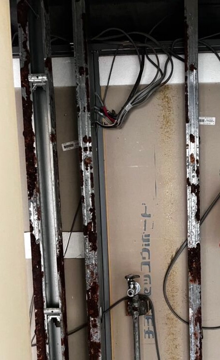 Electrical wiring exposed inside the wall after drywall demolition during a home renovation.