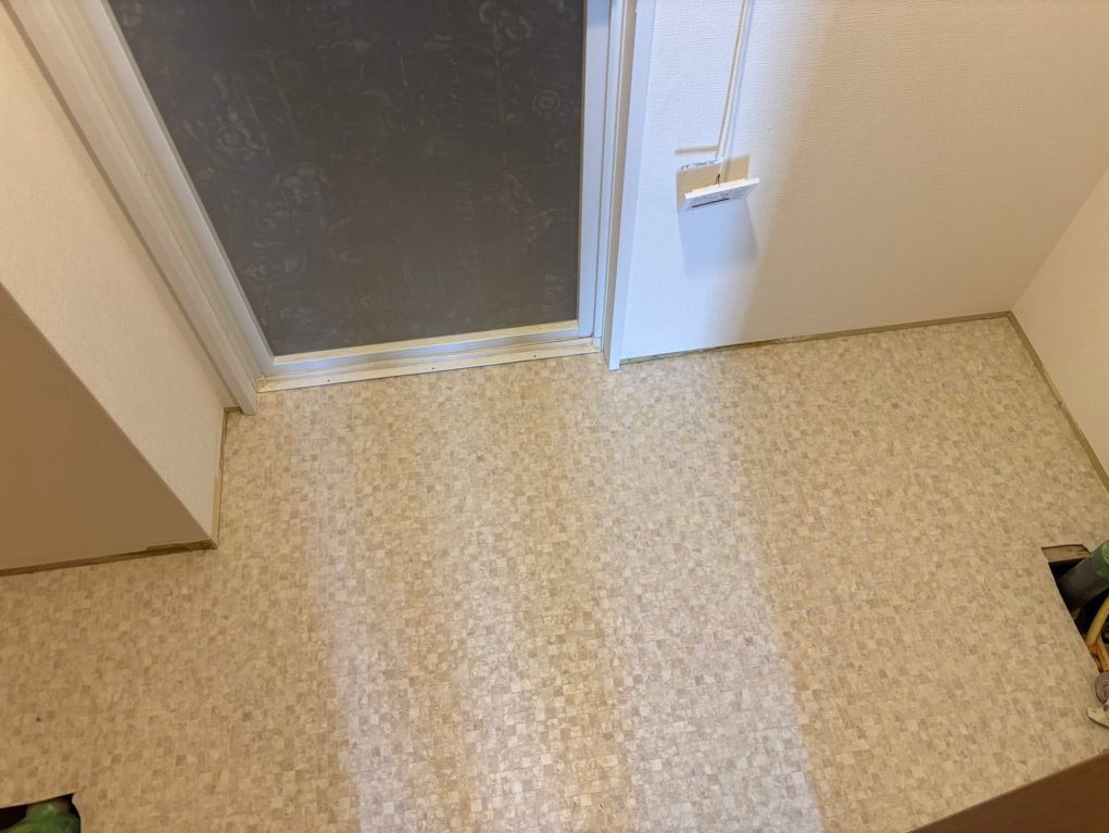 Completed vinyl flooring installation in the bathroom vanity and laundry area.