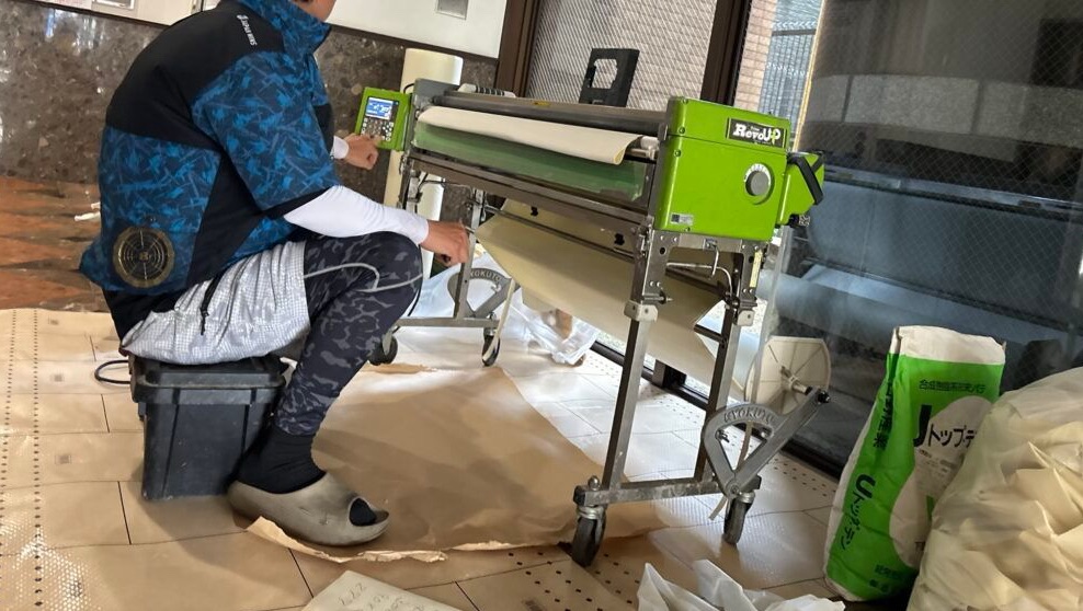 Professional wallpaper pasting machine preparing wallpaper for installation.