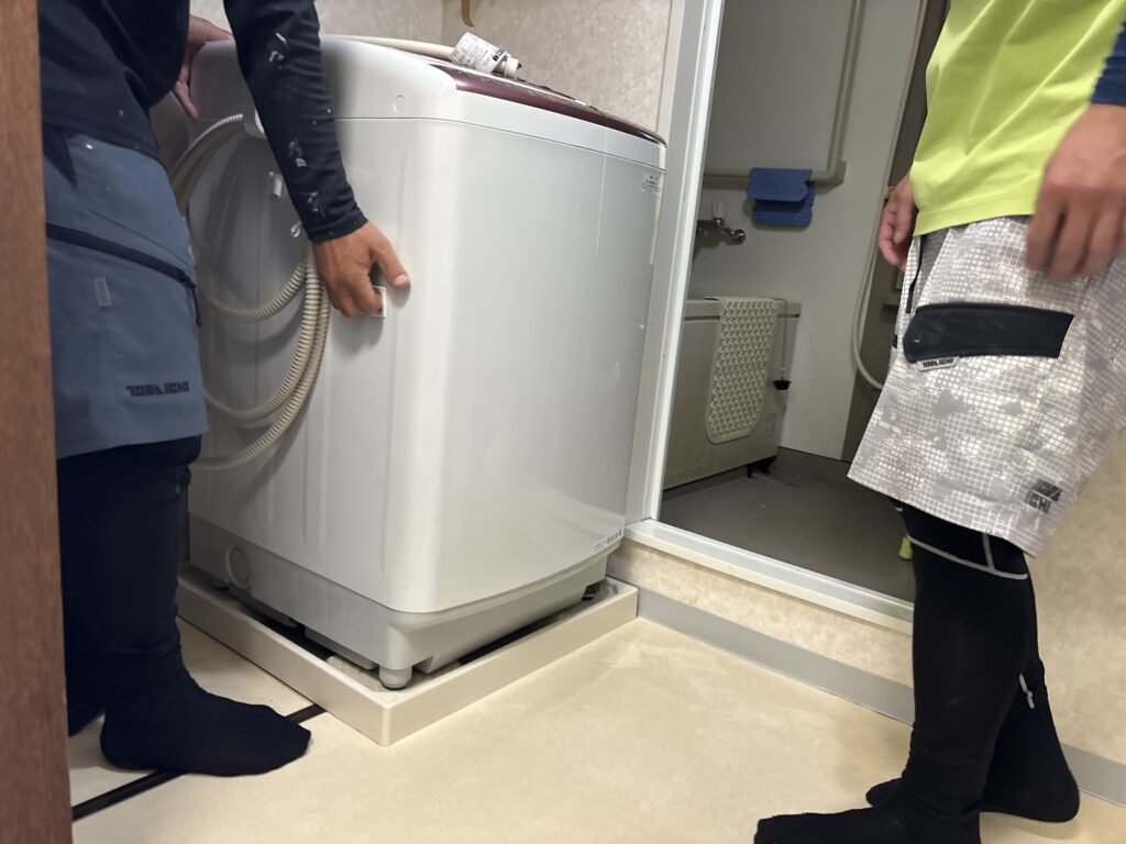 Laundry room before renovation with existing wallpaper, vinyl flooring, and fixtures in an occupied home.