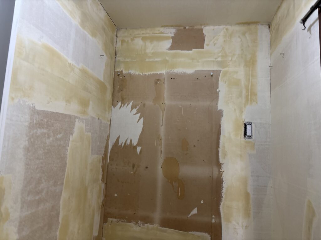 Finishing compound applied to prepare the wall for thin patterned wallpaper.