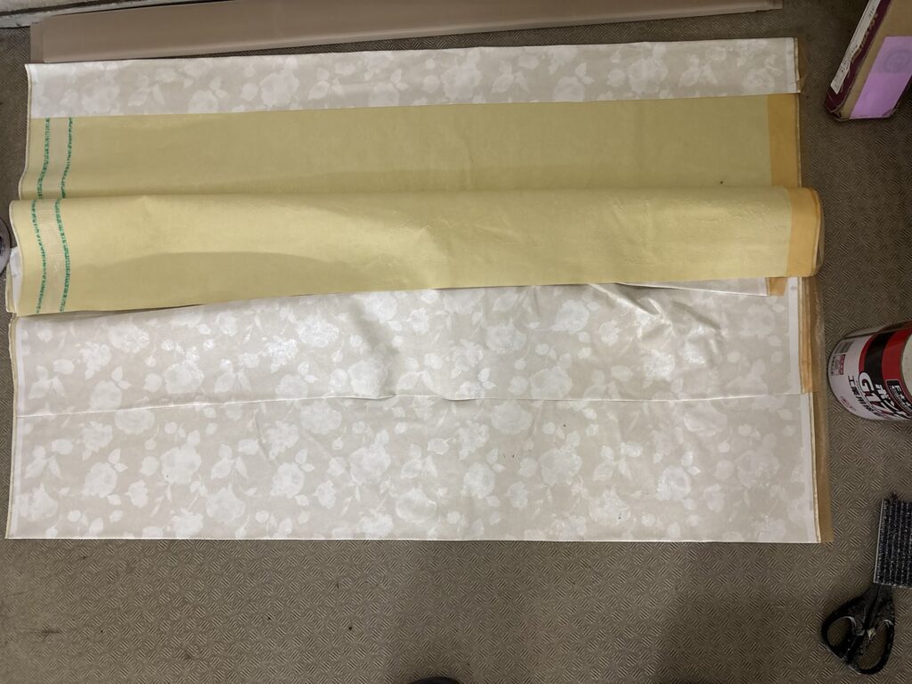 Green cutting tape and orange adhesive protection tape applied to wallpaper edges.