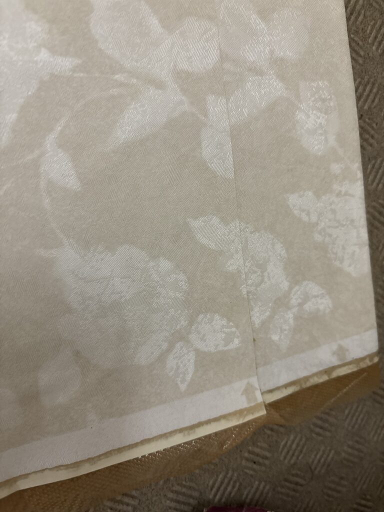 Close-up of pattern matching arrows printed on patterned wallpaper for accurate installation and seamless alignment.
