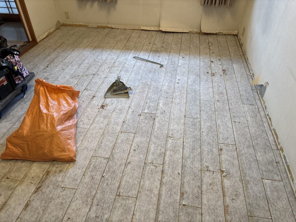 White cushion backing remaining on the subfloor after removing old flooring