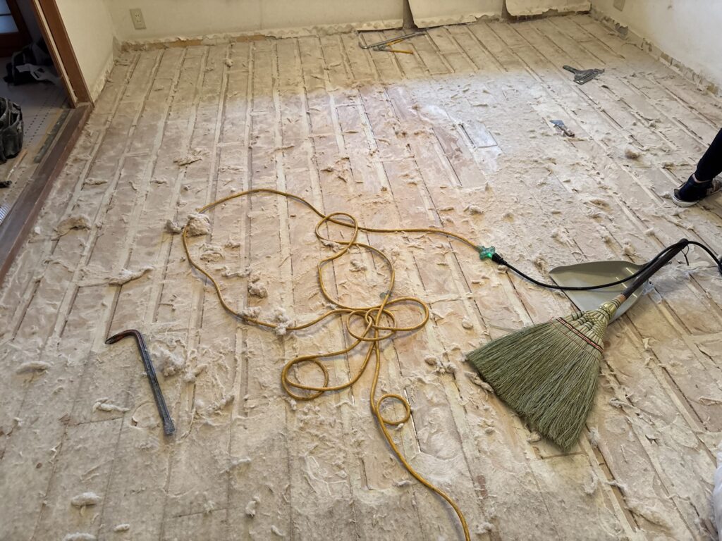 Partially removed white cushion backing during subfloor preparation