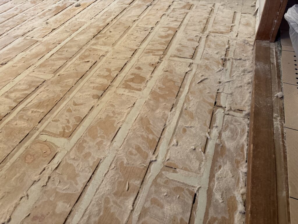 Narrow wooden subfloor boards discovered beneath old apartment flooring