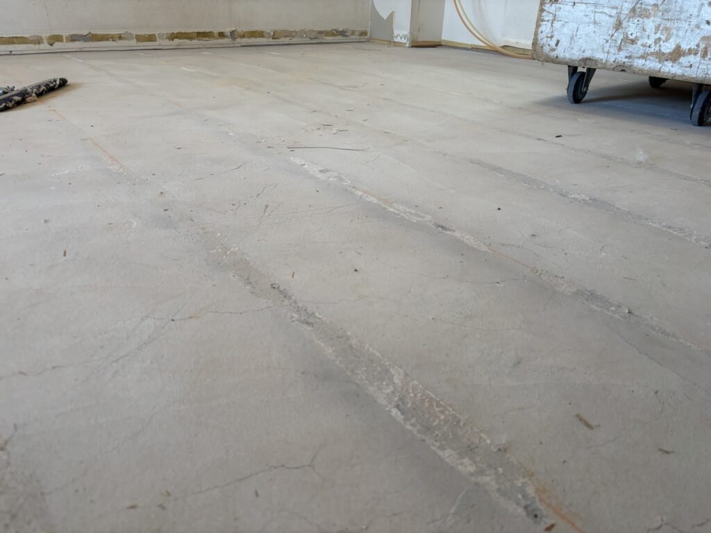 Living room after removing old flooring and subfloor materials during renovation