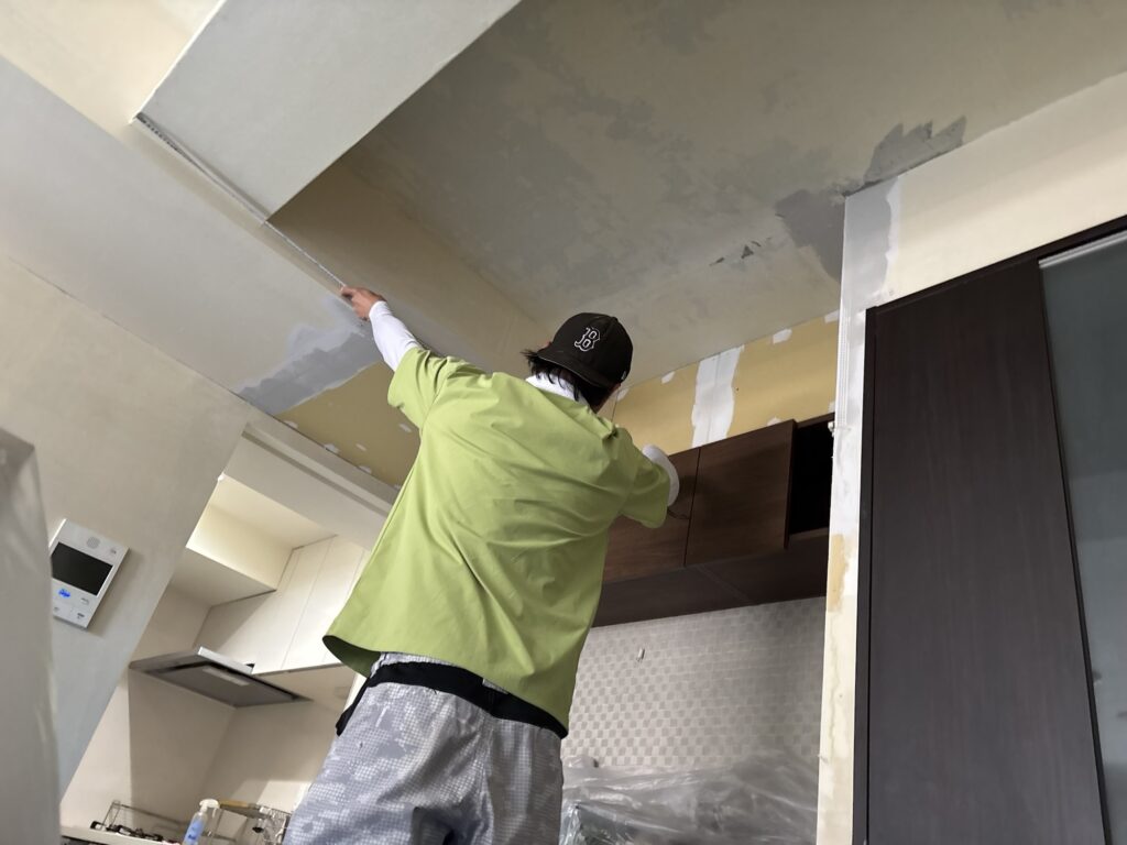 Wallpaper installer measuring a wall to determine the correct dimensions before wallpaper installation.