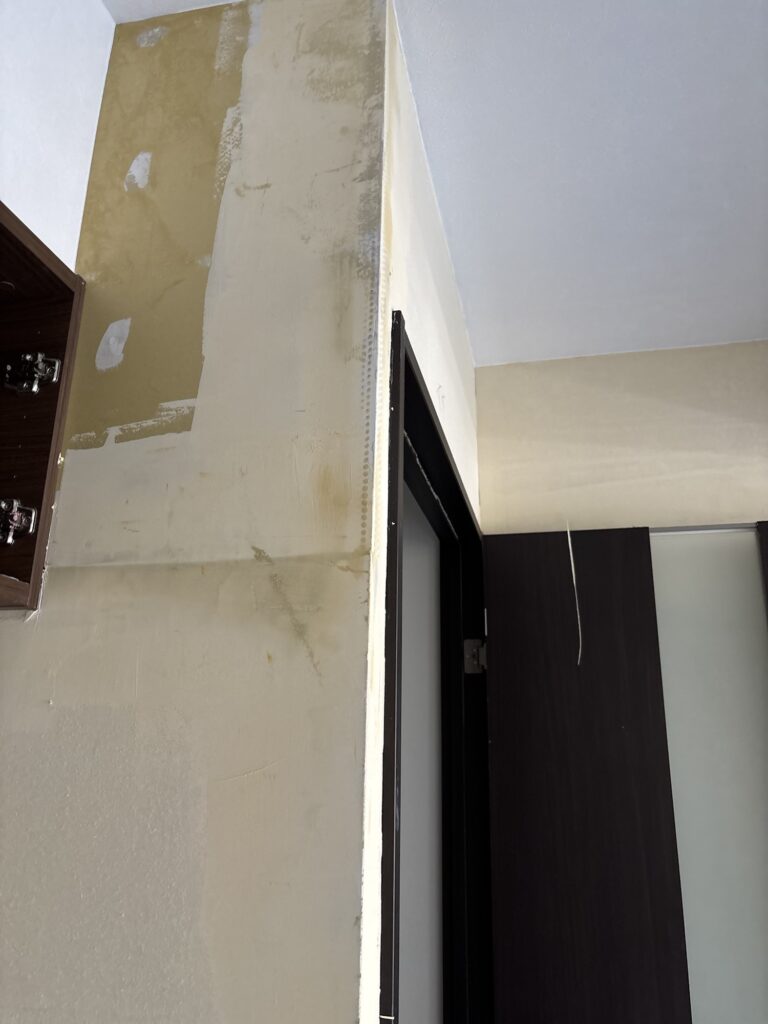 Wall surface prepared with finishing joint compound before wallpaper installation.