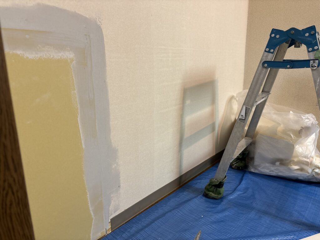 Old wallpaper removed from a wall before new wallpaper installation in a Japanese apartment.