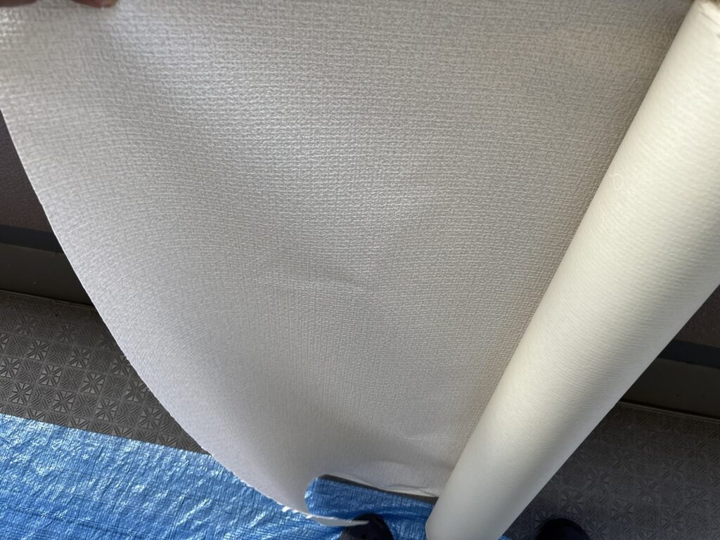 Embossed stone-textured wallpaper prepared for installation in a fifth-floor Japanese condominium.