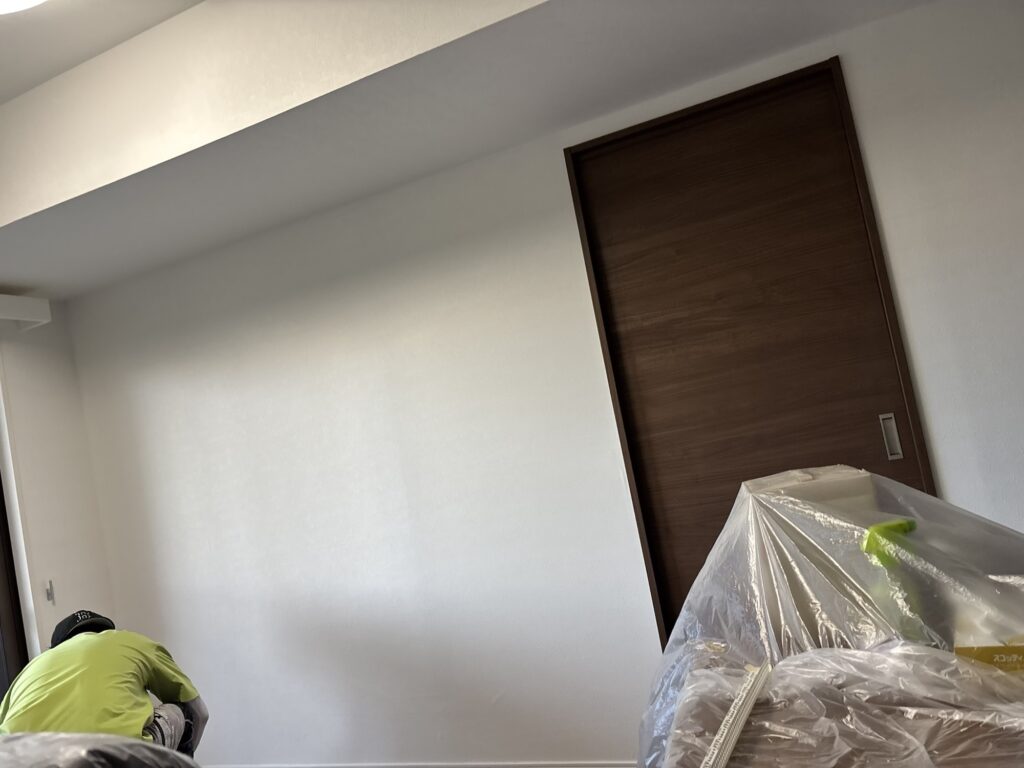 Completed wallpaper installation on a living room wall in a Japanese condominium.