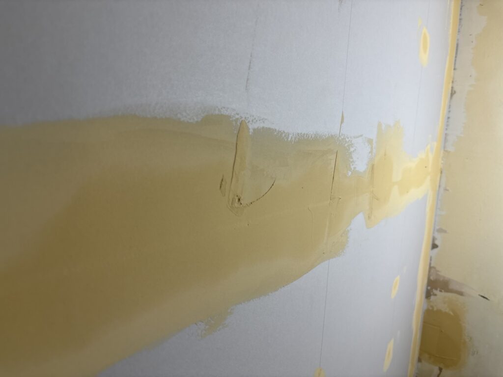 Raised putty areas on gypsum board before wallpaper installation