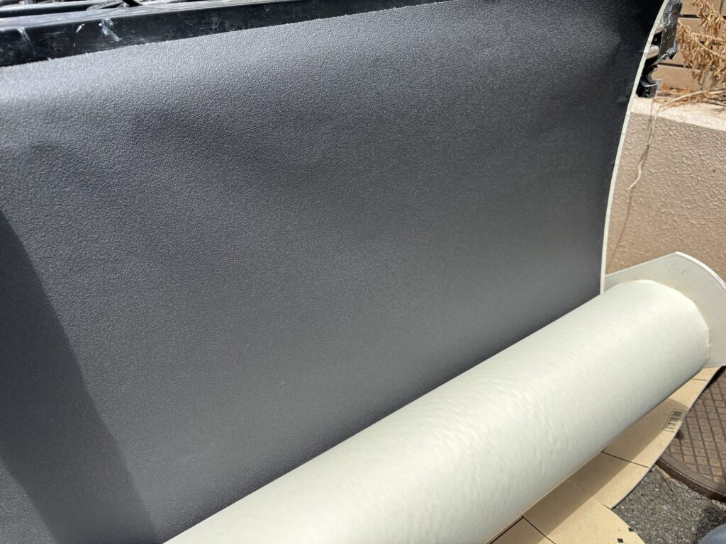 Thin black wallpaper material prepared for commercial interior installation
