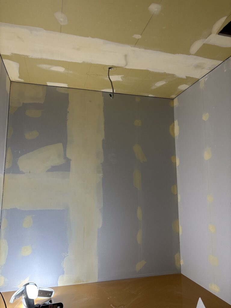 Finished gypsum board surface after applying finishing putty before wallpaper installation