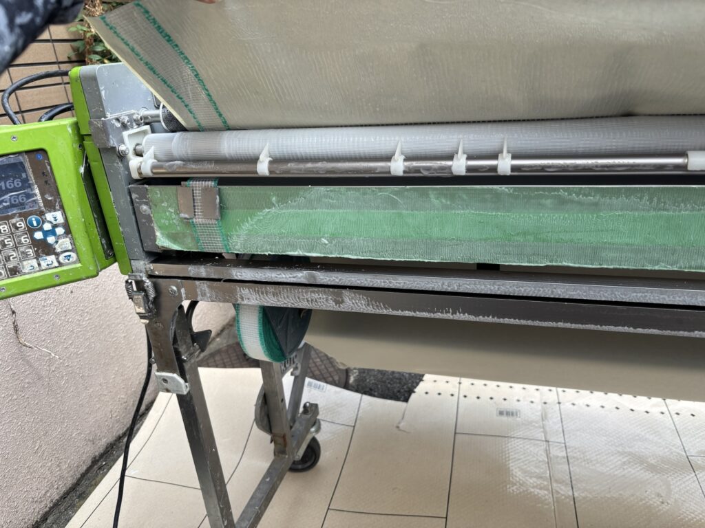 Thin black wallpaper with green backing tape prepared for wallpaper installation