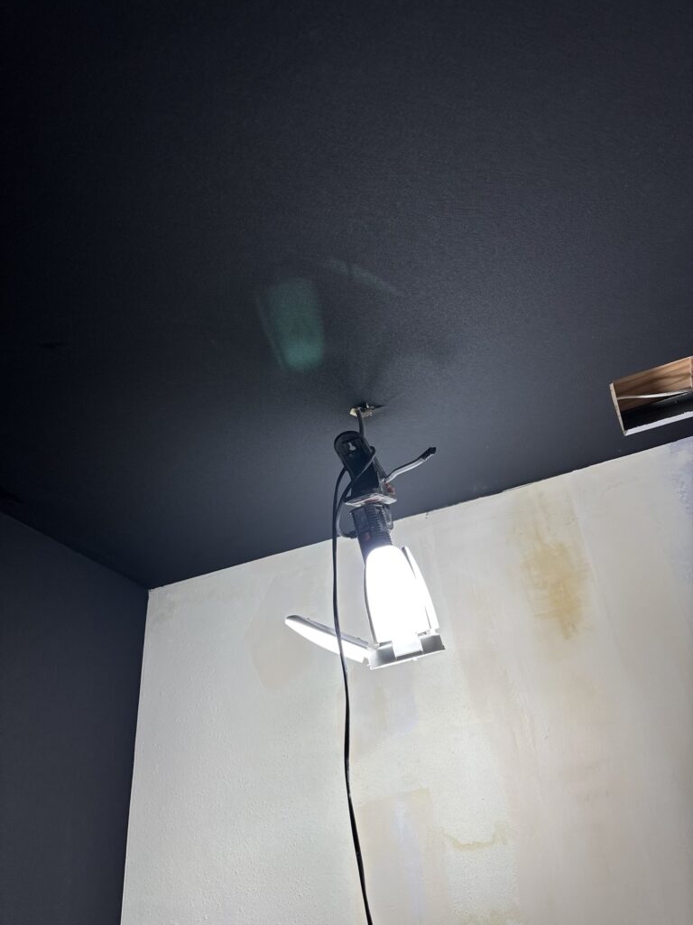 Completed installation of thin black wallpaper on a commercial room ceiling