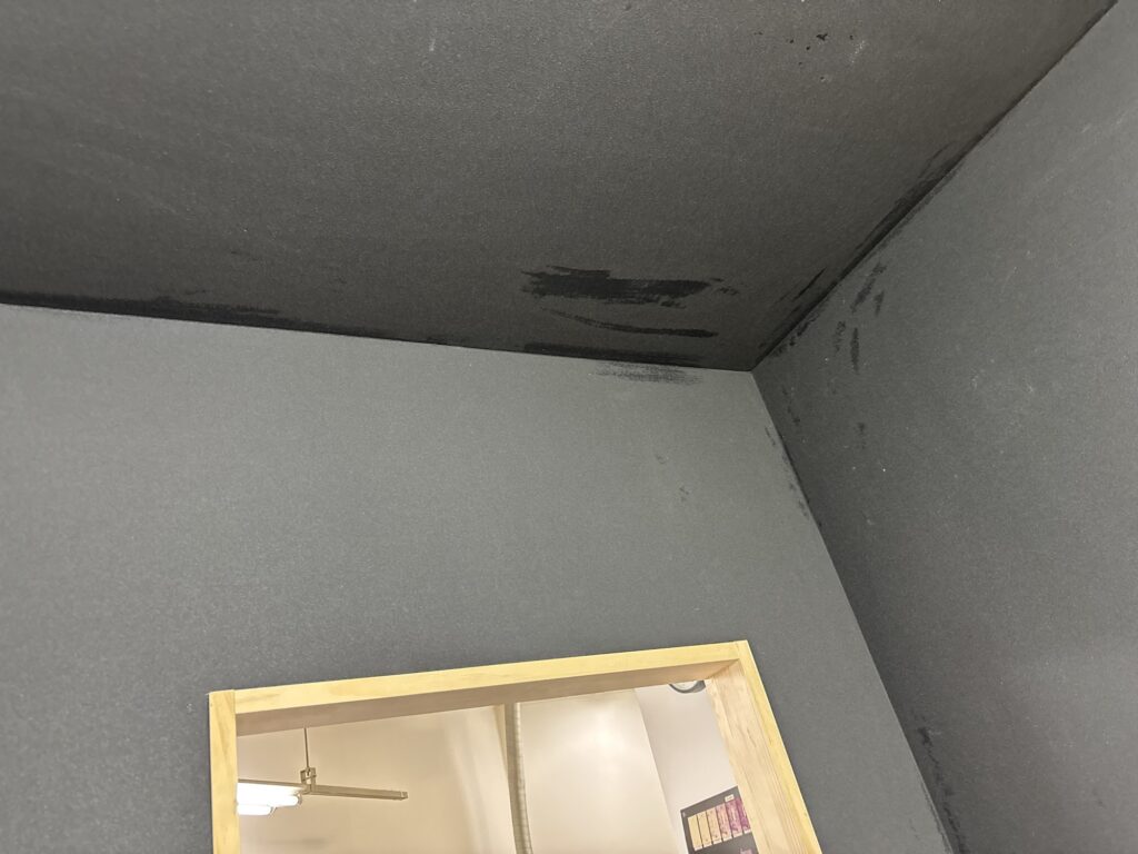Thin black wallpaper installed above a window frame
