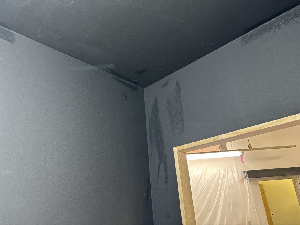 Completed black wallpaper installation in a small commercial room