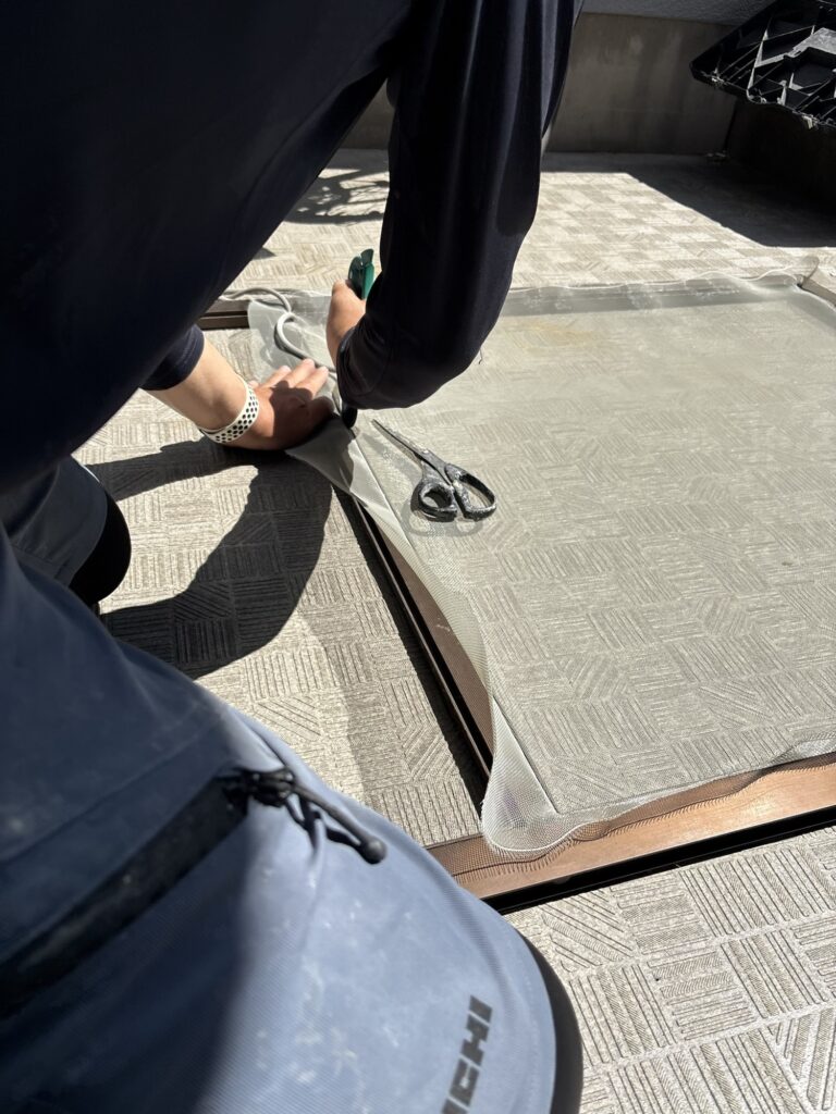 Stretching new screen mesh while installing rubber spline on a Japanese sliding screen door