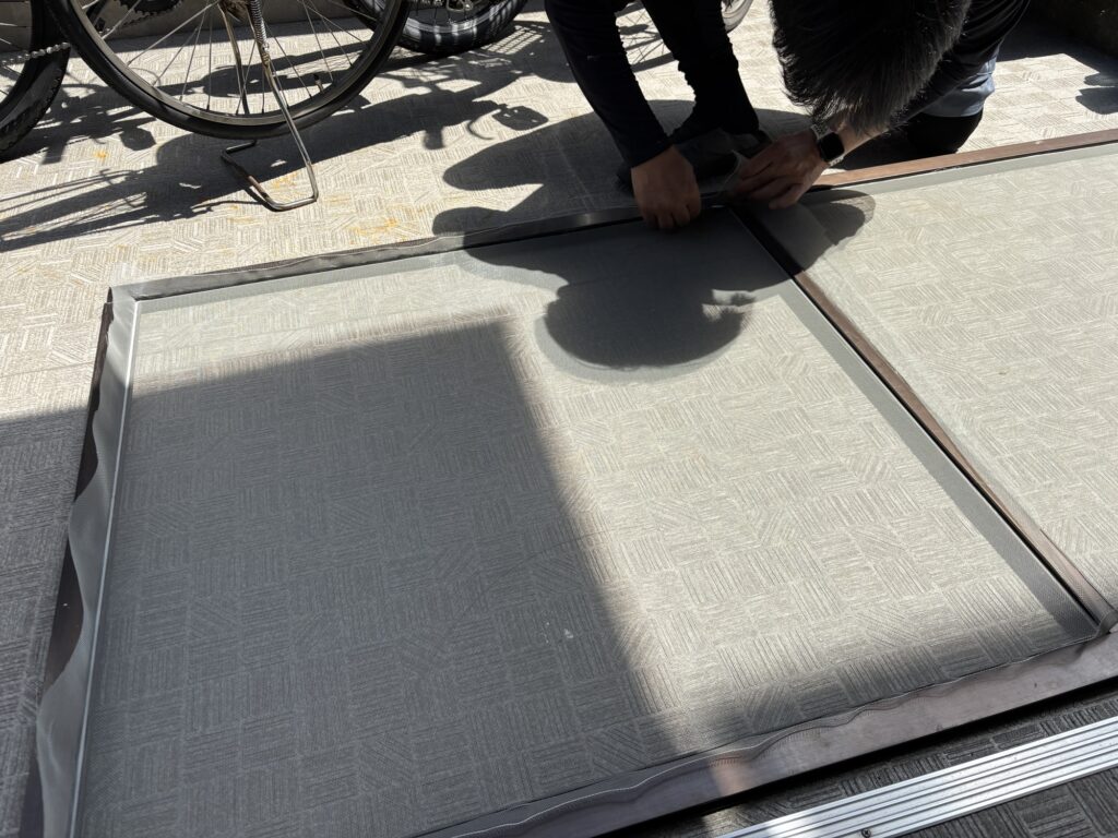 Cutting excess screen mesh with a utility knife after installing the spline