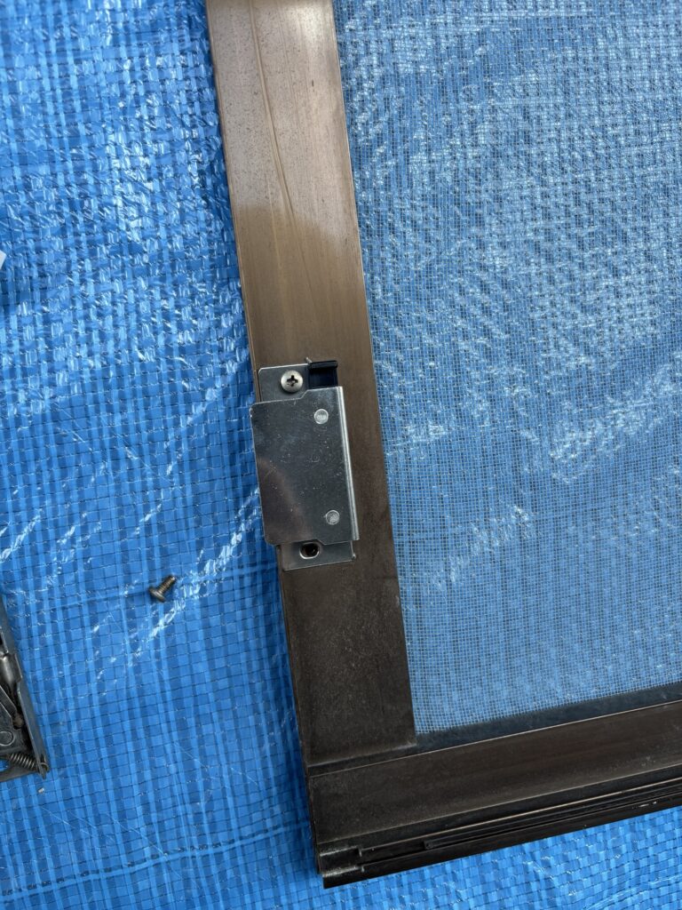 Installing a new roller on a Japanese sliding screen door during a home maintenance project