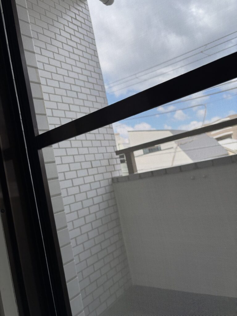 Completed Japanese sliding screen door with new screen mesh and replacement roller after repair