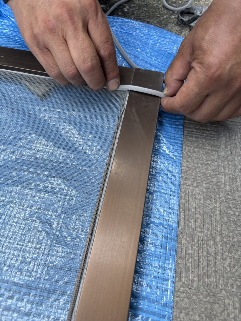 Checking the thickness of a new rubber spline before installing screen mesh on a Japanese sliding screen door
