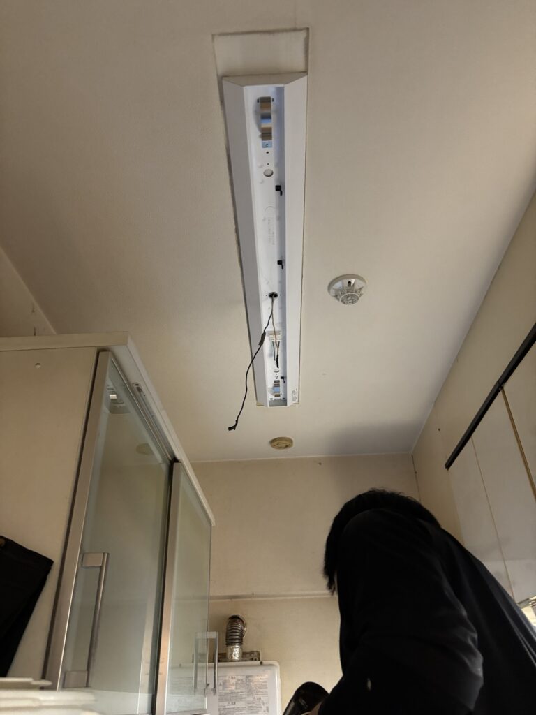 Installing a new kitchen ceiling light fixture on a concrete ceiling in a Japanese home