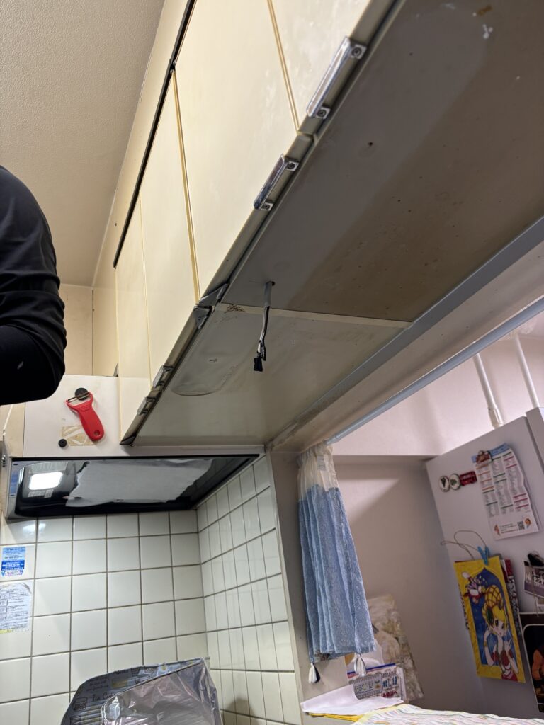 Removing an old under-cabinet light fixture in a Japanese kitchen
