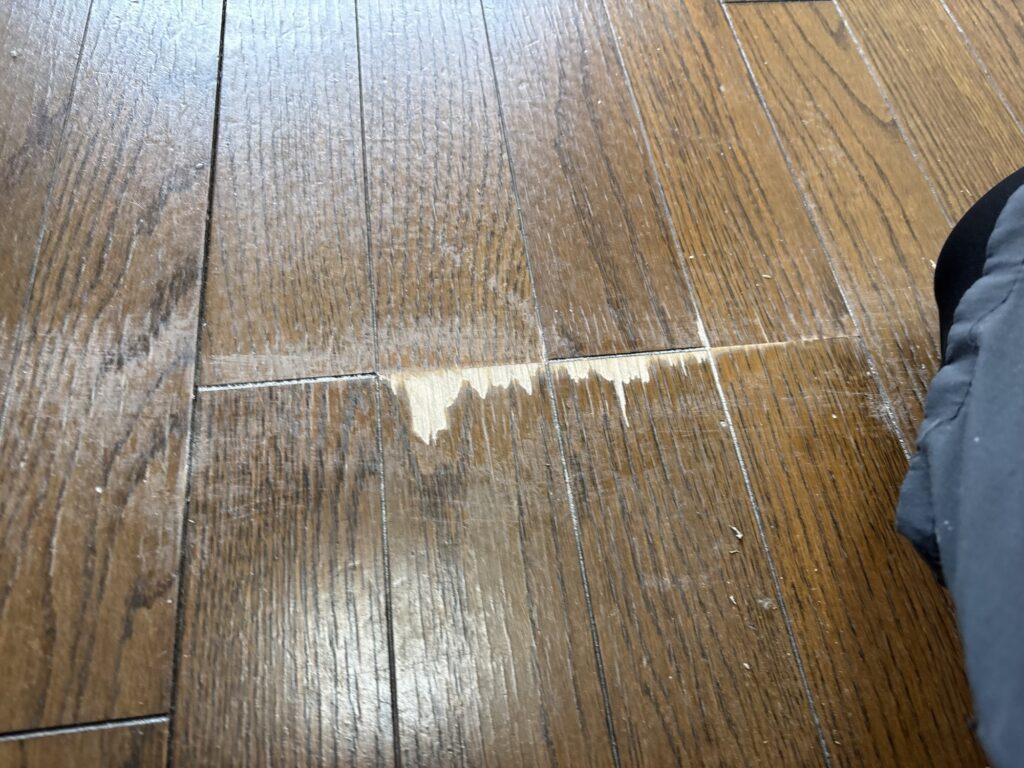 Deteriorated wood flooring partially removed before surface preparation for vinyl flooring.