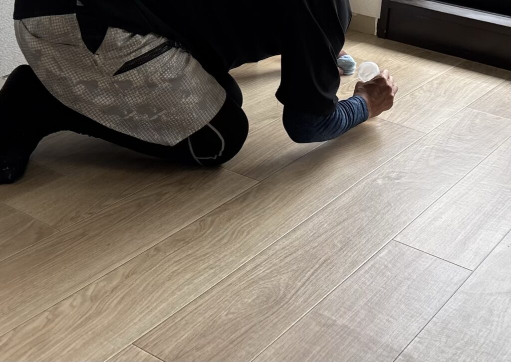 Seam sealer being applied along the joint between two vinyl flooring sheets.