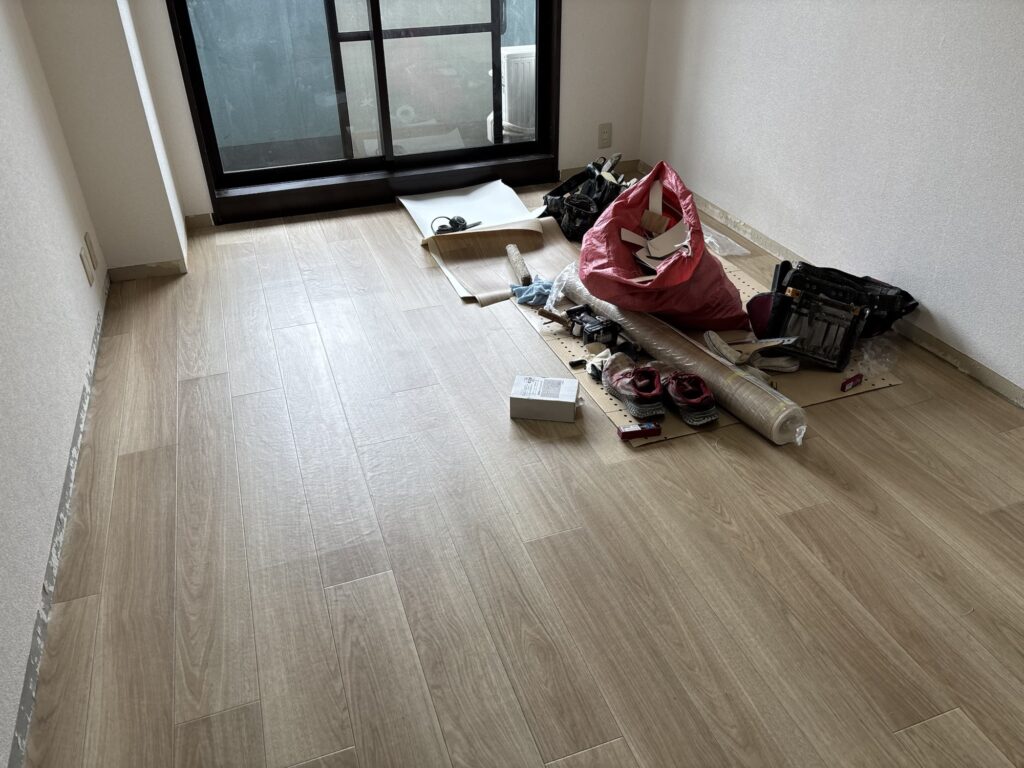 Completed cushion vinyl flooring installation with a clean and even surface in the apartment.
