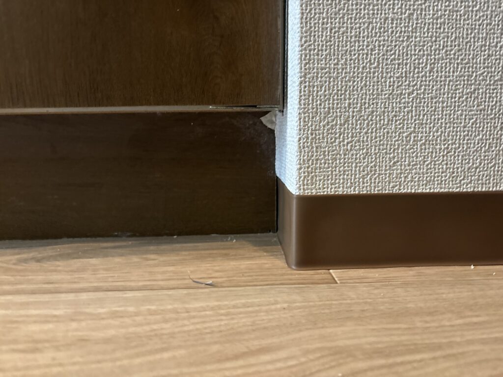 Soft vinyl baseboard being wrapped around a corner during an apartment renovation.