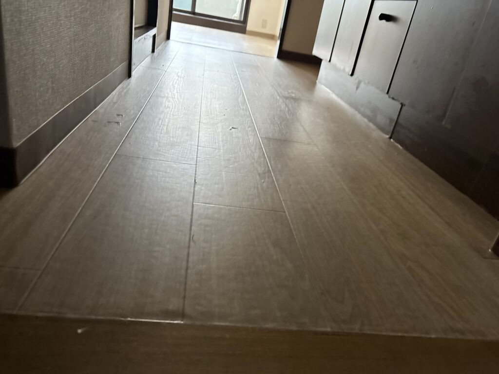 Completed kitchen area featuring newly installed cushion vinyl flooring and soft vinyl baseboards along the walls.
