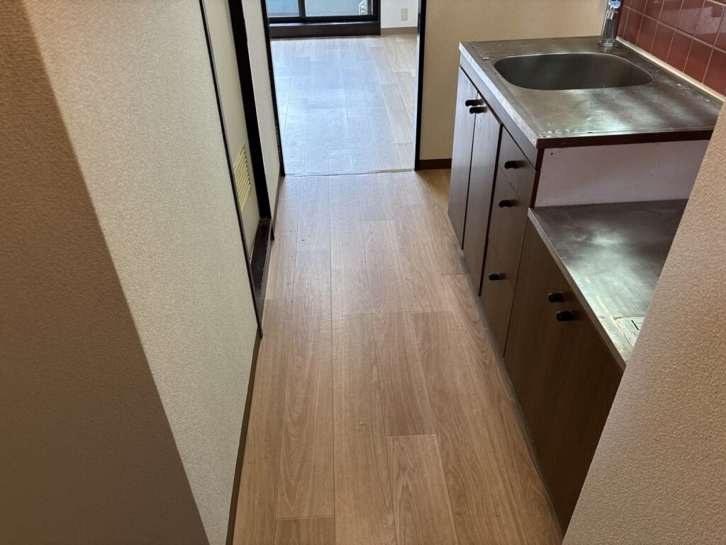 Finished kitchen with newly installed cushion vinyl flooring and soft vinyl baseboard in a Japanese apartment.