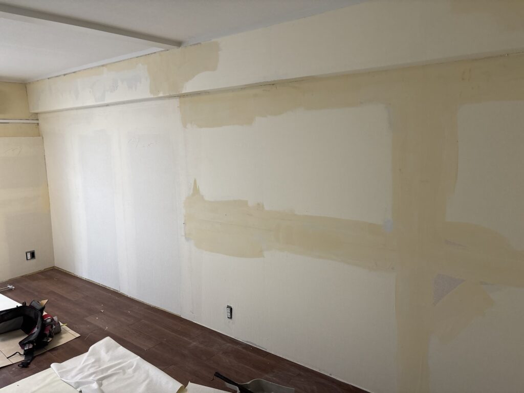 Apartment walls with old wallpaper removed and joint compound applied before new wallpaper installation.