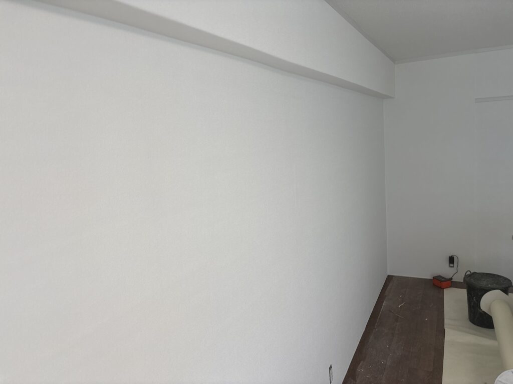 New embossed wallpaper installed on a prepared wall in an older Japanese apartment.