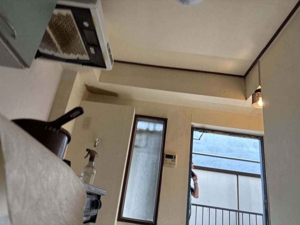 Plasterboard wall exposed after removing old wallpaper in a Japanese apartment kitchen.