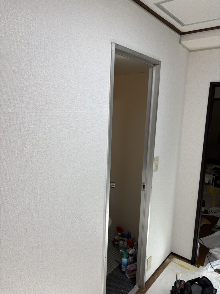 Completed wallpaper installation on the walls of a small Japanese apartment kitchen.