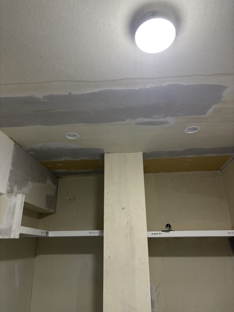 Basecoat joint compound applied to the repaired gypsum board ceiling before finishing and wallpaper installation.