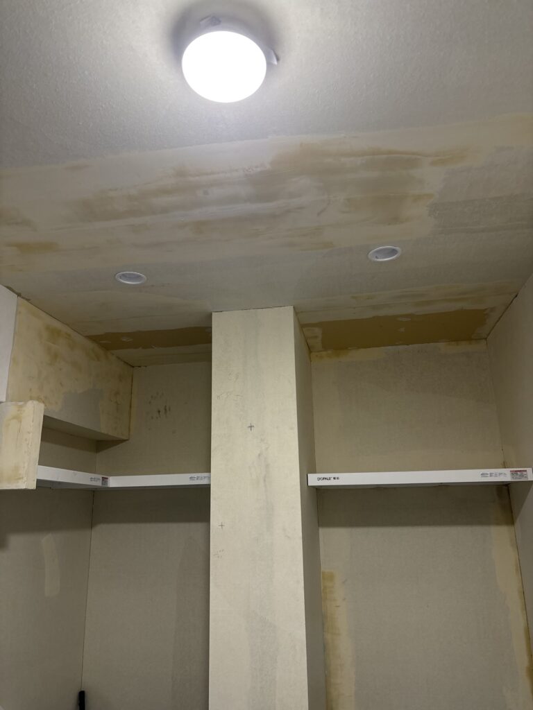 Repaired gypsum board ceiling covered with finishing joint compound before wallpaper installation.