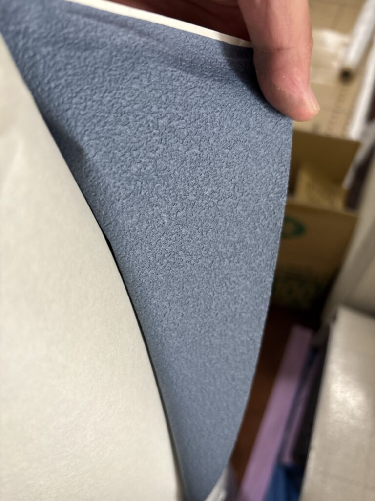 Close-up of navy blue wallpaper material prepared for wall installation in a Japanese apartment.