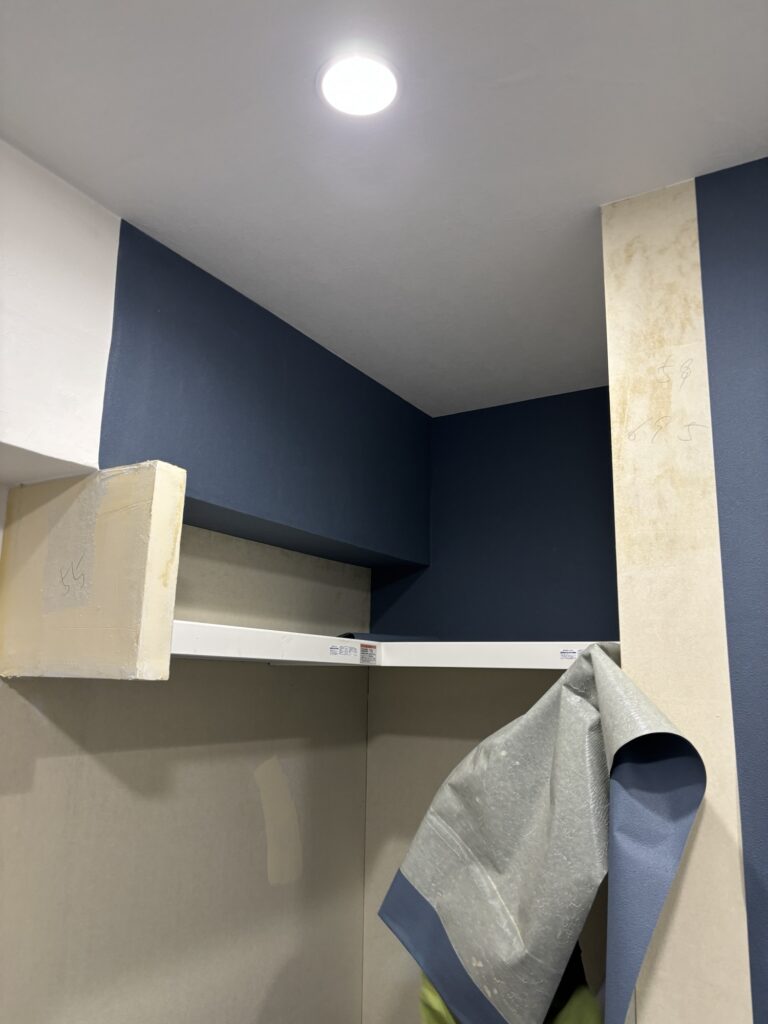 Straight joint between white and navy wallpaper on a beam in a Japanese apartment.