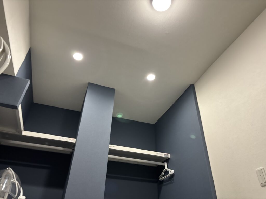Completed wallpaper replacement in a Japanese apartment with a white ceiling and navy blue walls.