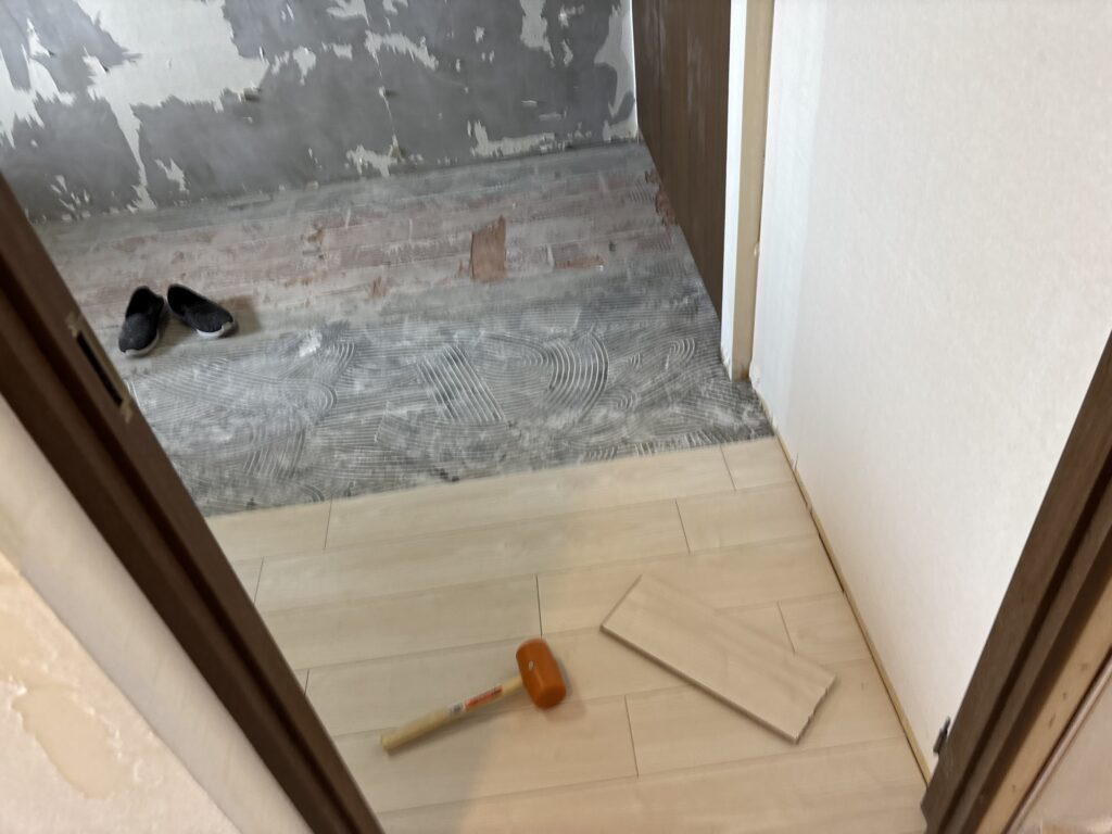 Wood flooring installation in progress with several rows of flooring boards already installed.