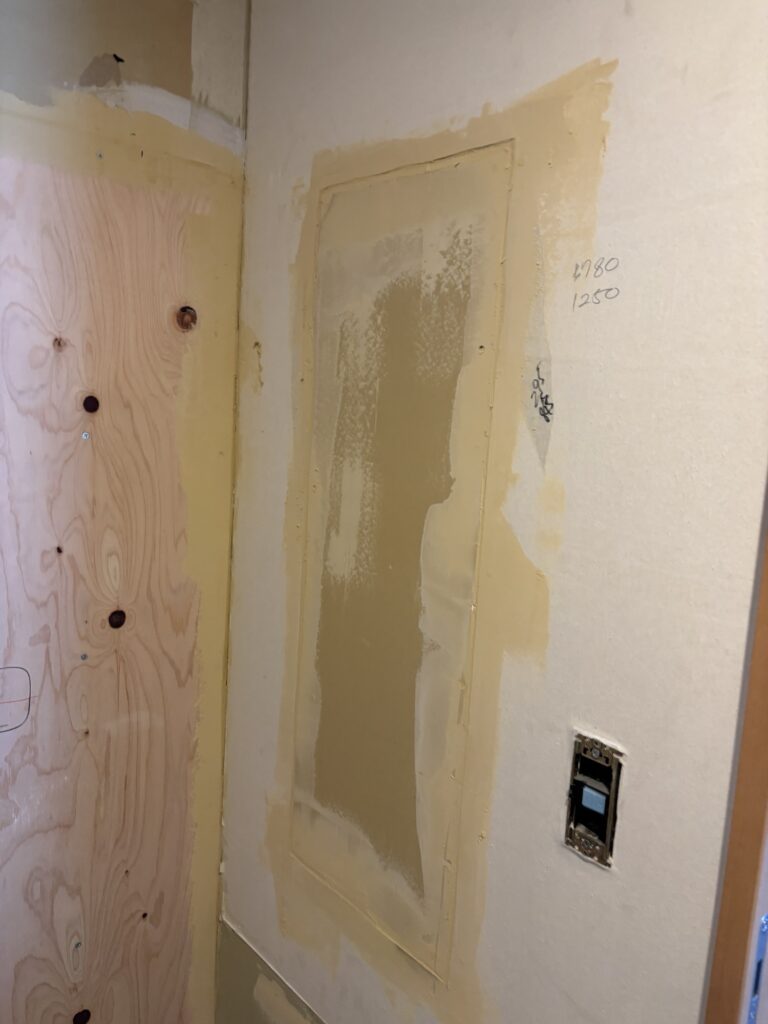 Bathroom vanity and washing machine area before wallpaper and vinyl flooring replacement.